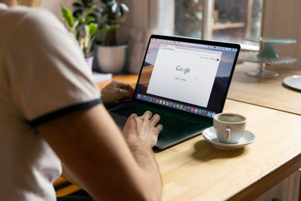 an image of a person sat at a laptop with Google Search on screen to introduce the blog creating a google my business account without a specific location