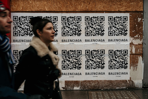 Person walking infornt of a wall of qr codes